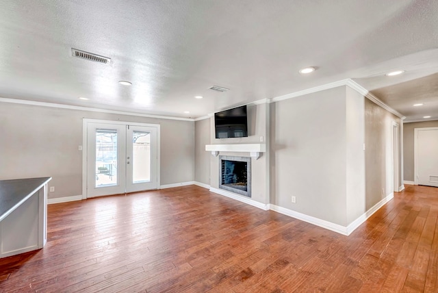 1002 Boyd Ave, Midland, TX 79705 - unfurnished living room featuring hardwood / wood-style floors, ornamental molding, baseboards, visible vents, and a fireplace
