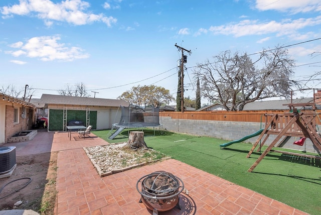 1002 Boyd Ave, Midland, TX 79705 - view of patio / terrace with central AC unit, a playground, a trampoline, a fenced backyard, and a fire pit