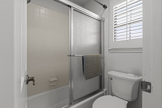 bathroom featuring toilet and enclosed tub / shower combo