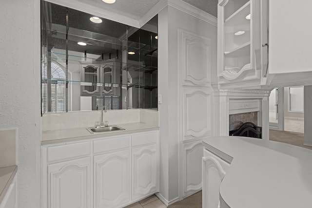 interior space with a textured ceiling, wet bar, a textured wall, and a sink