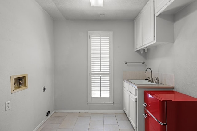 clothes washing area featuring washer hookup, cabinet space, electric dryer hookup, a textured ceiling, and a sink