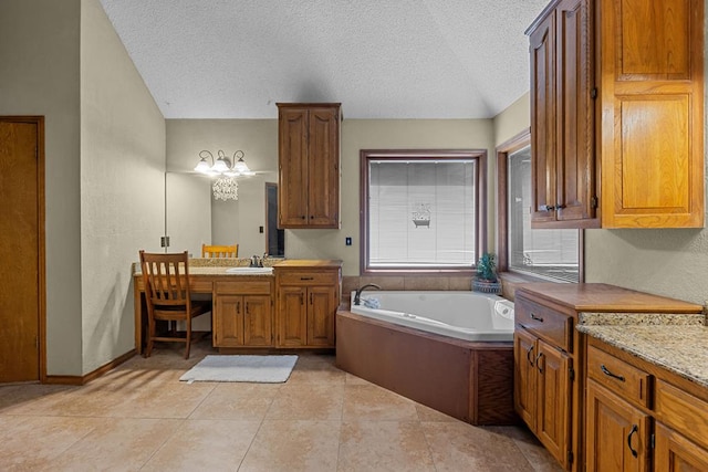 bathroom featuring lofted ceiling, tile patterned flooring, vanity, a textured ceiling, and a tub to relax in