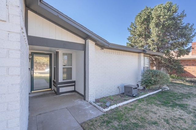 view of exterior entry featuring brick siding