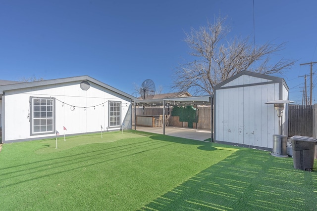 view of yard featuring a storage shed, an outbuilding, and a fenced backyard