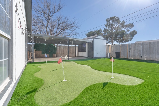 view of yard featuring a storage unit, an outbuilding, and a fenced backyard