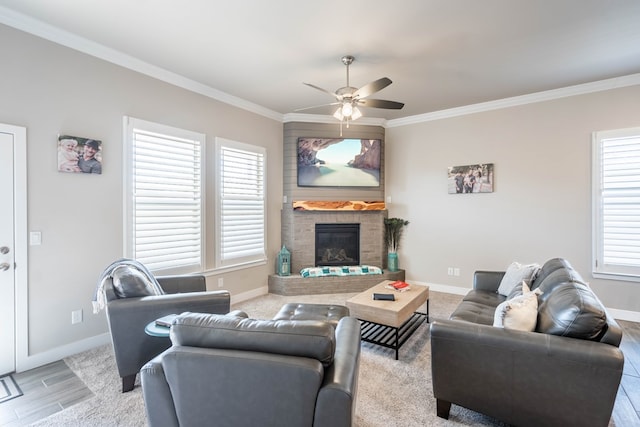 living room with crown molding, plenty of natural light, and a large fireplace