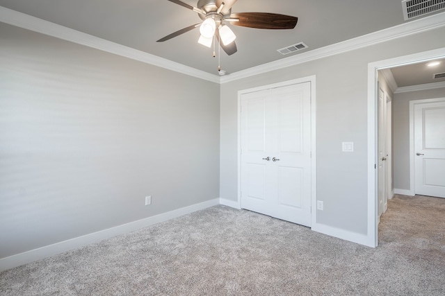 unfurnished bedroom featuring ceiling fan, light colored carpet, and ornamental molding