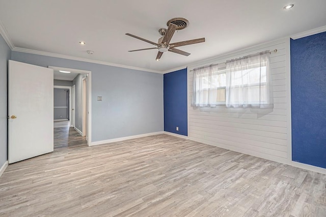 empty room featuring crown molding, baseboards, ceiling fan, and wood finished floors