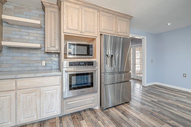 kitchen with french doors, appliances with stainless steel finishes, dark hardwood / wood-style floors, and backsplash