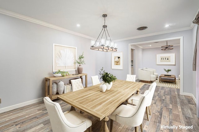 dining space featuring baseboards, wood finished floors, and ornamental molding