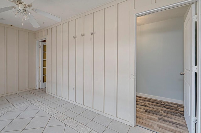 interior space with ceiling fan, light tile patterned floors, and baseboards