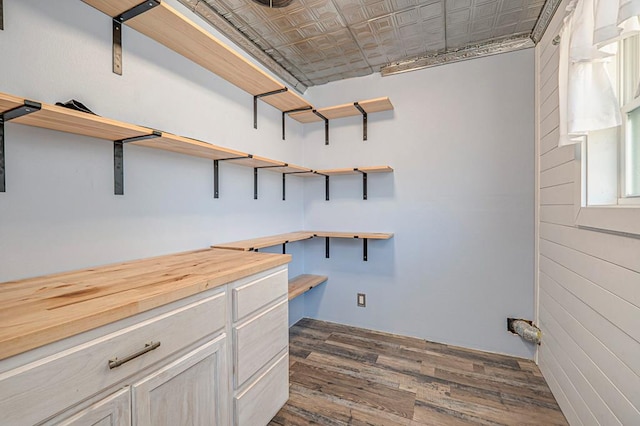 laundry room featuring dark wood finished floors and an ornate ceiling