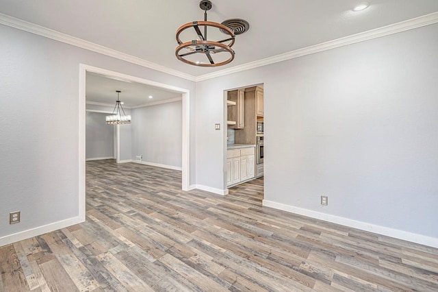 unfurnished dining area with crown molding, a notable chandelier, and light hardwood / wood-style flooring