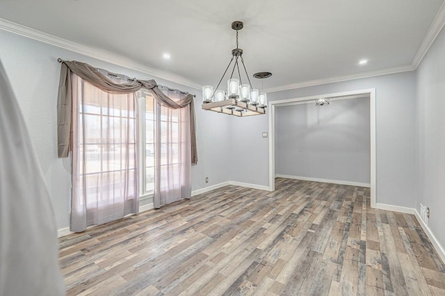 unfurnished dining area featuring ornamental molding, a notable chandelier, baseboards, and wood finished floors