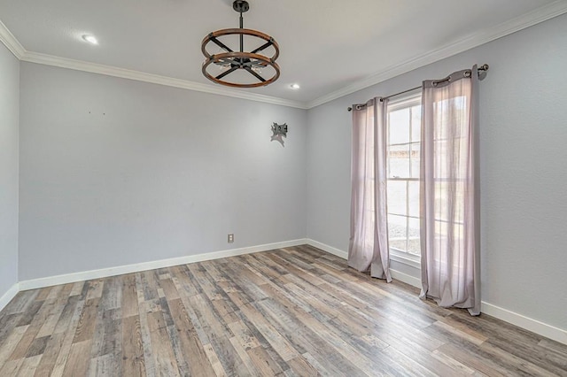 empty room featuring crown molding, recessed lighting, a ceiling fan, wood finished floors, and baseboards