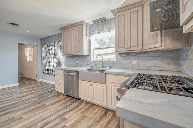 kitchen featuring light wood-style flooring, a sink, visible vents, light countertops, and stainless steel dishwasher