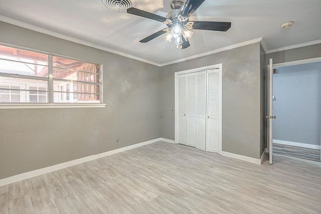 unfurnished bedroom featuring baseboards, wood finished floors, and ornamental molding