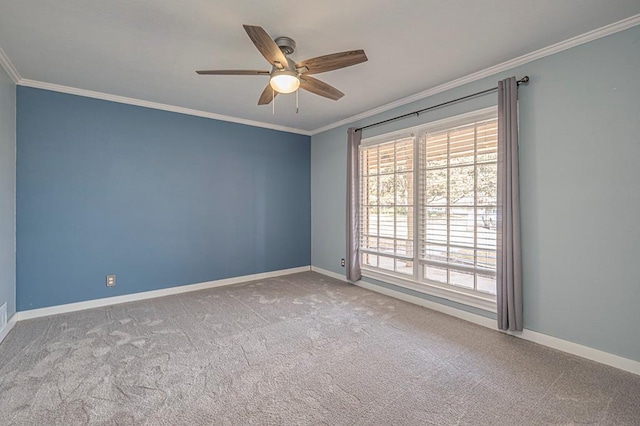 carpeted spare room featuring ornamental molding, a ceiling fan, and baseboards