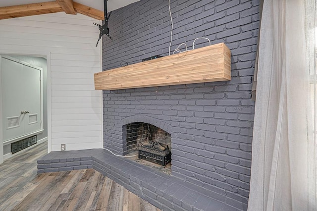 details featuring wood walls, a fireplace, and wood finished floors