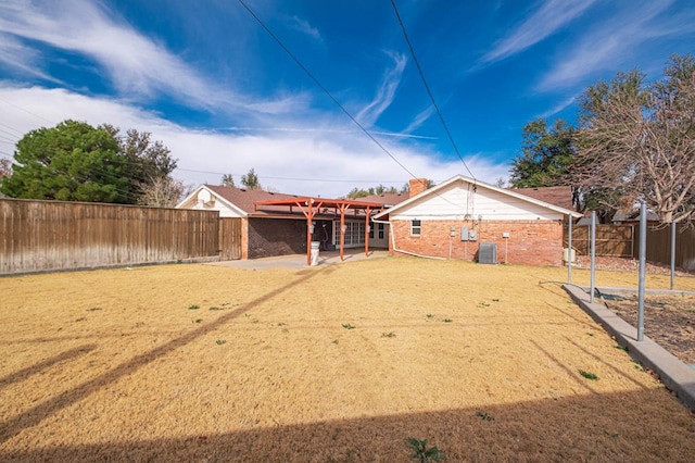 back of house with a yard, central AC unit, and a patio