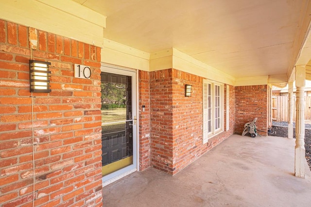 view of exterior entry featuring brick siding