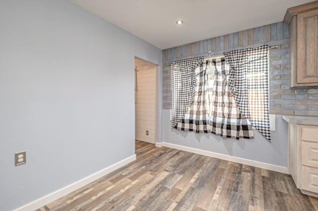 unfurnished dining area featuring recessed lighting, baseboards, and wood finished floors