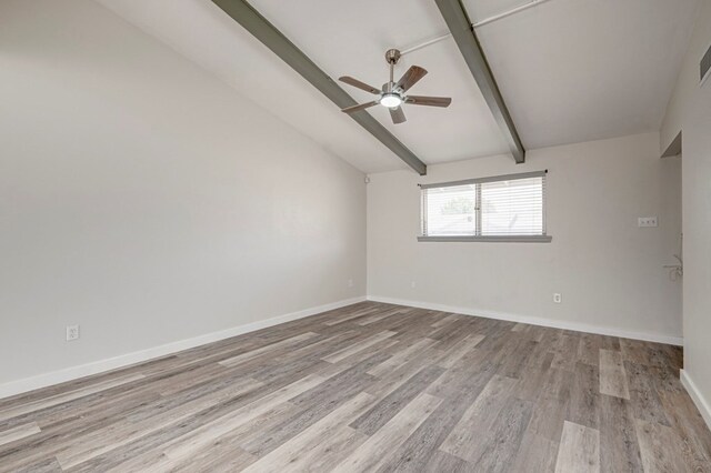 spare room featuring baseboards, vaulted ceiling with beams, a ceiling fan, and wood finished floors