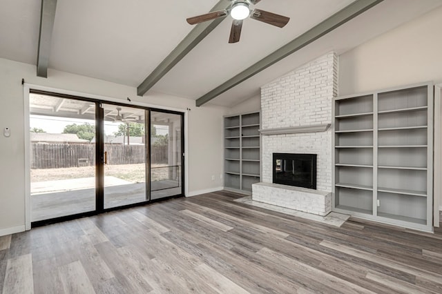 unfurnished living room featuring vaulted ceiling with beams, a ceiling fan, and wood finished floors