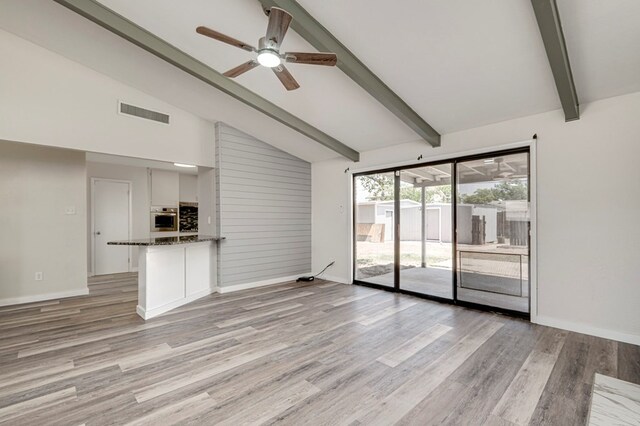 unfurnished living room with light wood-style flooring, a ceiling fan, baseboards, beamed ceiling, and visible vents