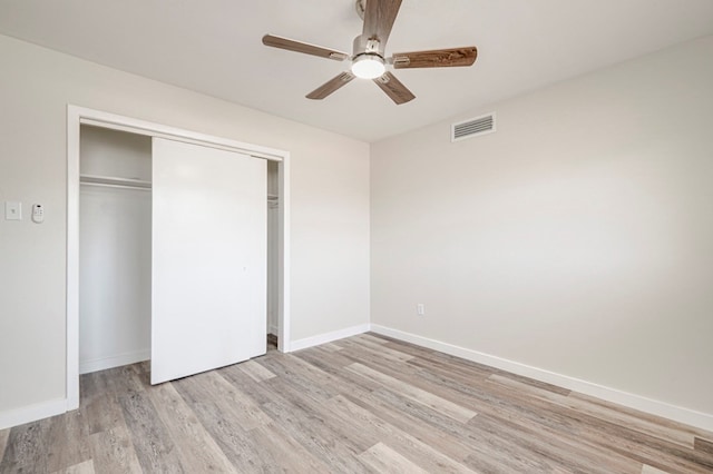 unfurnished bedroom featuring visible vents, light wood-style flooring, baseboards, and a closet