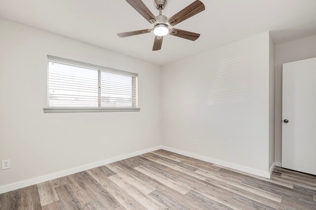 spare room featuring baseboards, a ceiling fan, and light wood-type flooring