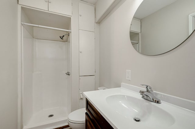 bathroom with vanity, toilet, and a stall shower
