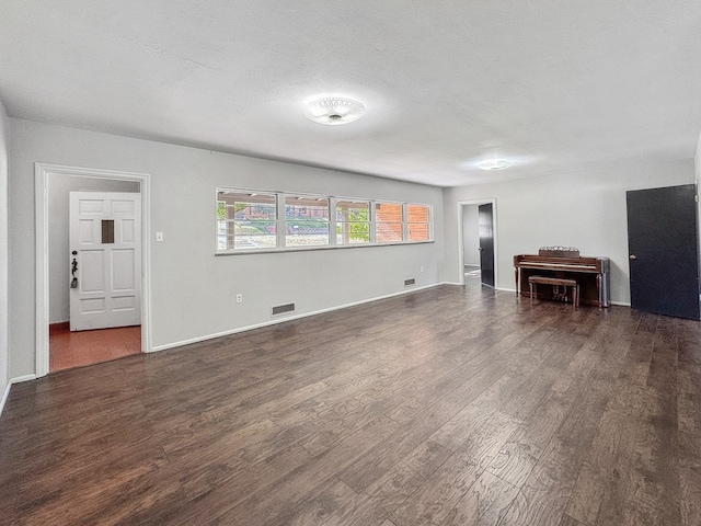 unfurnished living room featuring dark hardwood / wood-style floors and a textured ceiling