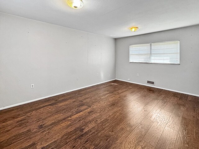 empty room with dark wood-type flooring