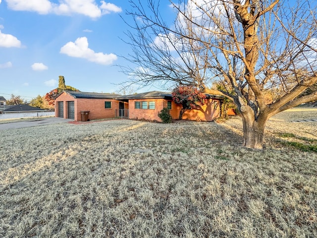 rear view of property featuring a garage and a yard