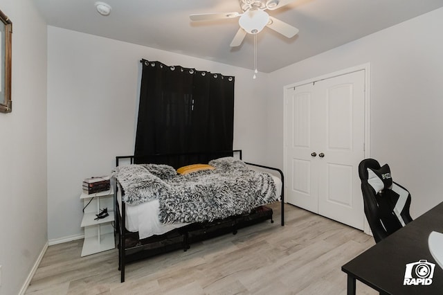 bedroom featuring light wood-style floors, a ceiling fan, baseboards, and a closet