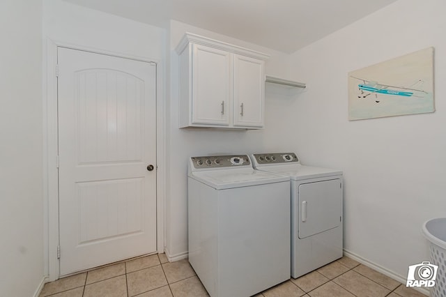 washroom with cabinet space, baseboards, separate washer and dryer, and light tile patterned flooring