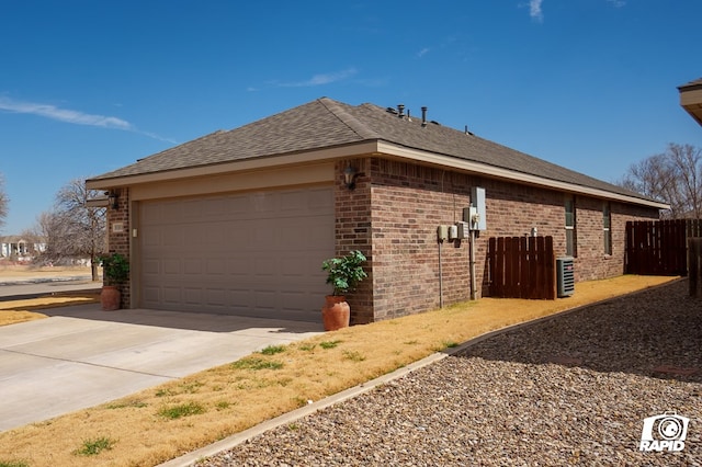 view of home's exterior with a garage, driveway, brick siding, and fence