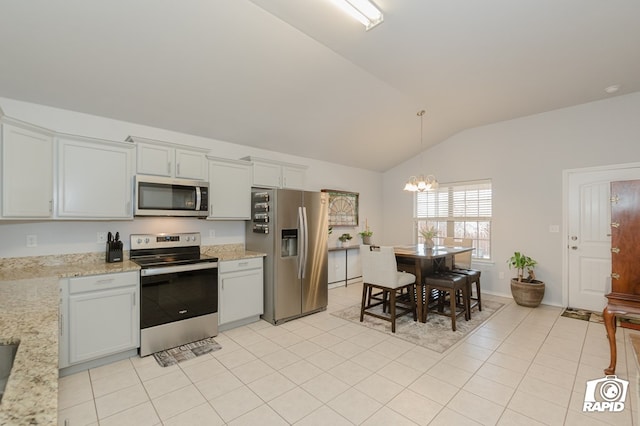 kitchen with light tile patterned floors, a notable chandelier, stainless steel appliances, vaulted ceiling, and pendant lighting