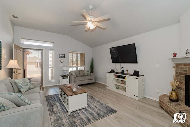 living area featuring light wood-type flooring, a brick fireplace, a ceiling fan, and lofted ceiling