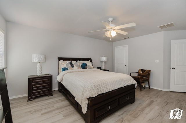 bedroom with a ceiling fan, light wood-type flooring, visible vents, and baseboards