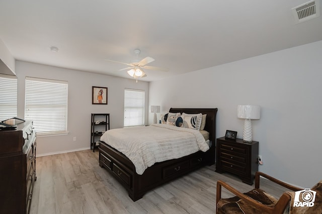 bedroom featuring light wood-style flooring, multiple windows, visible vents, and baseboards