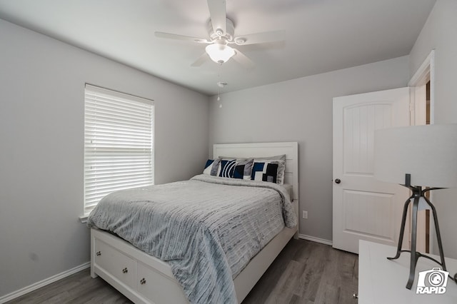 bedroom with ceiling fan, baseboards, and wood finished floors