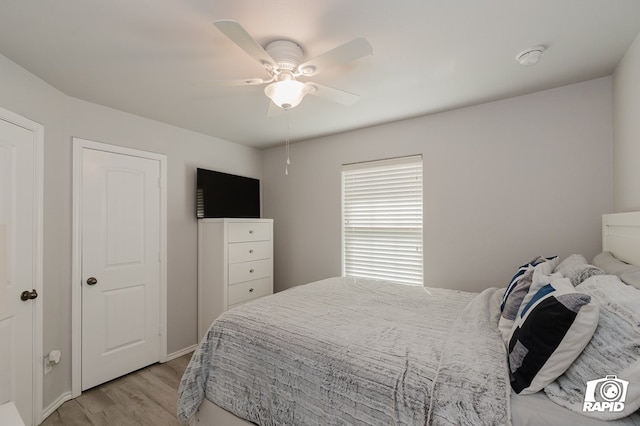 bedroom with light wood finished floors and a ceiling fan