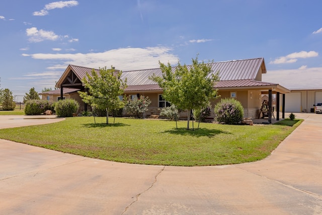 6811 Elkins Rd, Midland, TX 79705 - view of front facade featuring a front lawn, driveway, stone siding, a metal roof, and stucco siding