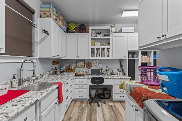 6811 Elkins Rd, Midland, TX 79705 - kitchen with built in desk, open shelves, light wood finished floors, white cabinets, and range