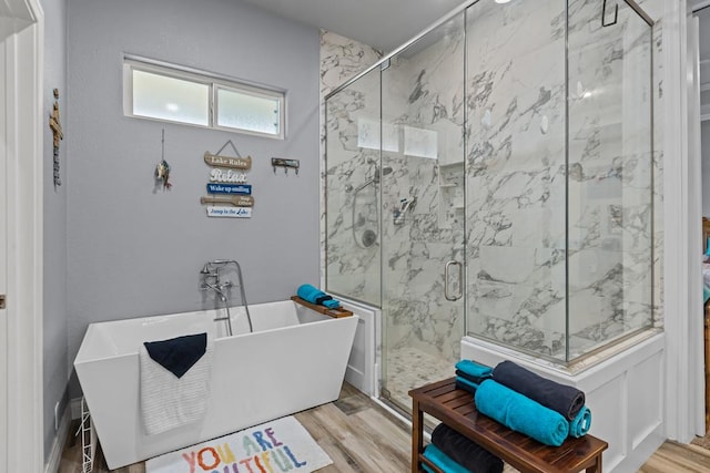 6811 Elkins Rd, Midland, TX 79705 - bathroom featuring wood finished floors, a freestanding tub, and a marble finish shower