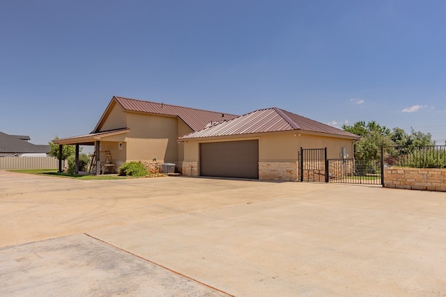 6811 Elkins Rd, Midland, TX 79705 - view of front facade with stone siding, stucco siding, driveway, and an attached garage