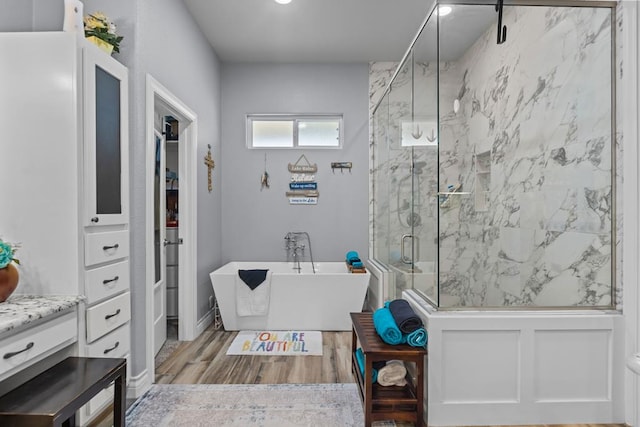 6811 Elkins Rd, Midland, TX 79705 - full bathroom with a freestanding tub, a marble finish shower, and wood finished floors