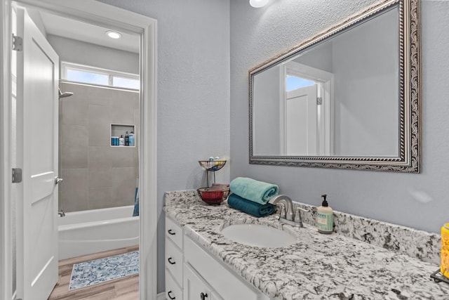 6811 Elkins Rd, Midland, TX 79705 - bathroom featuring vanity, wood finished floors, and bathing tub / shower combination